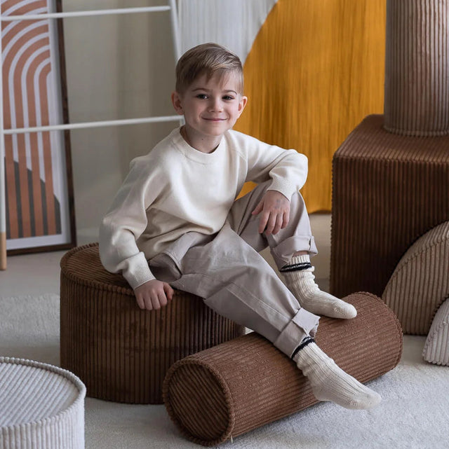 Mueble Puf Asiento Redondo de Pana Marrón en ambiente de estilo nórdico
