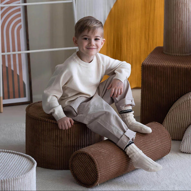 Mueble Cojín Cilindro de Pana Marrón en ambiente de estilo nórdico