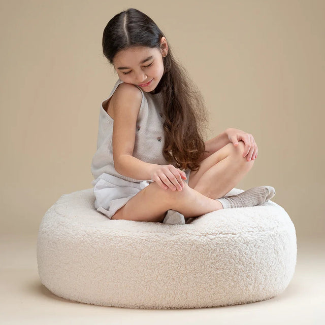 Mueble Puf Redondo de Borreguito Blanco Crema con acabado blanco, acabado crema en ambiente de estilo nórdico